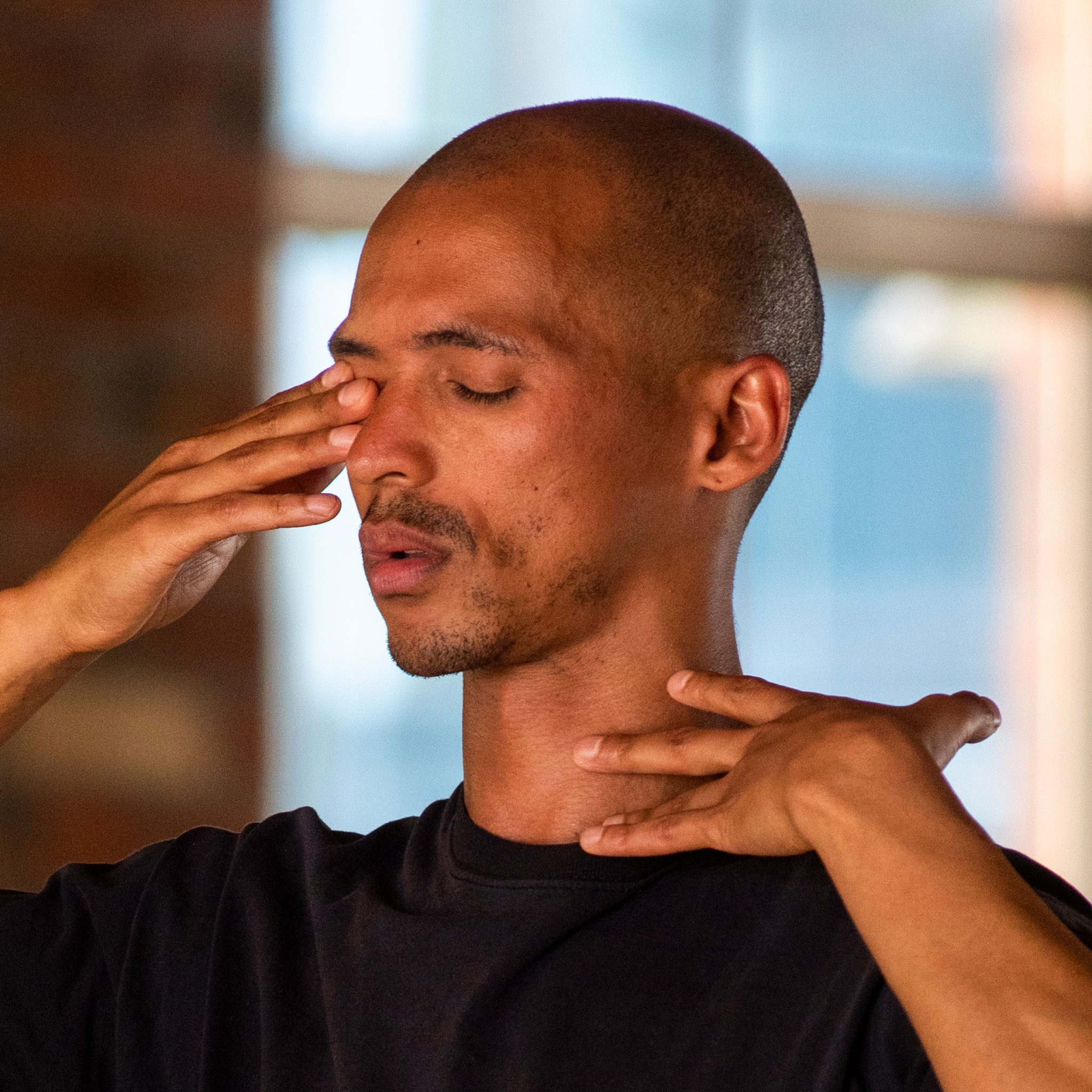 Tiran Willemse in a studio setting, eyes closed, with hand gestures